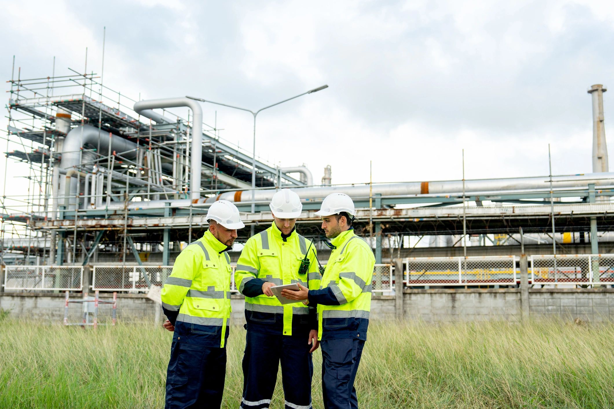 Factory engineers and technicians standing in front of a refinery